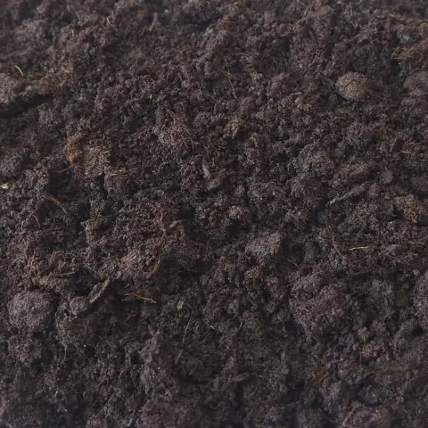 Donkerbruine turfgrond met vezelige kluitjes en fijne wortels