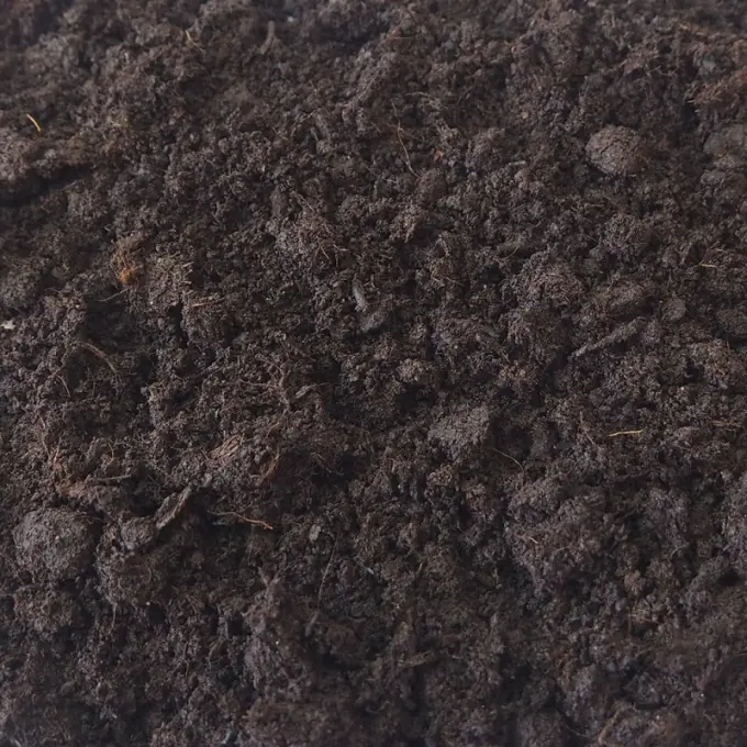 Donkerbruine turfgrond met vezelige kluitjes en fijne wortels