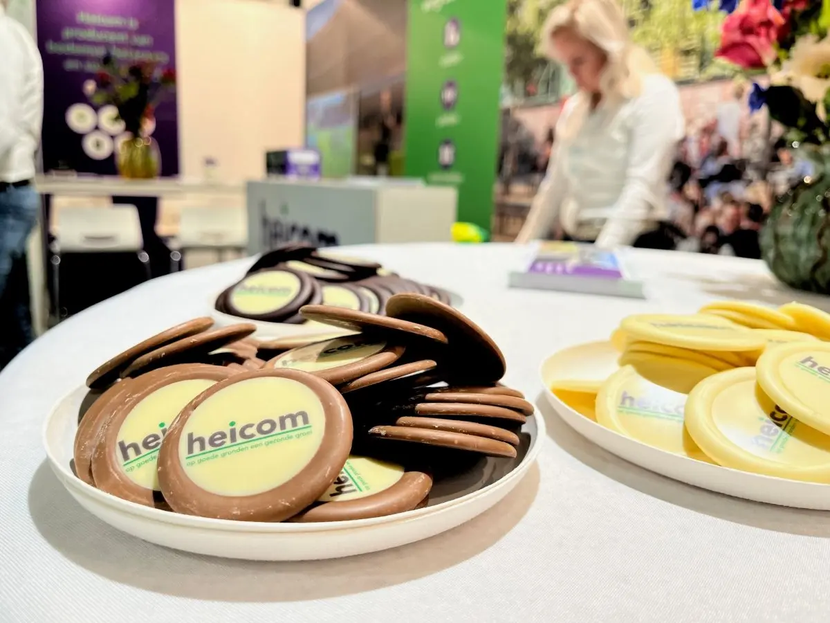 Schaal chocolaatjes met heicom-logo op een tafel op een beurs