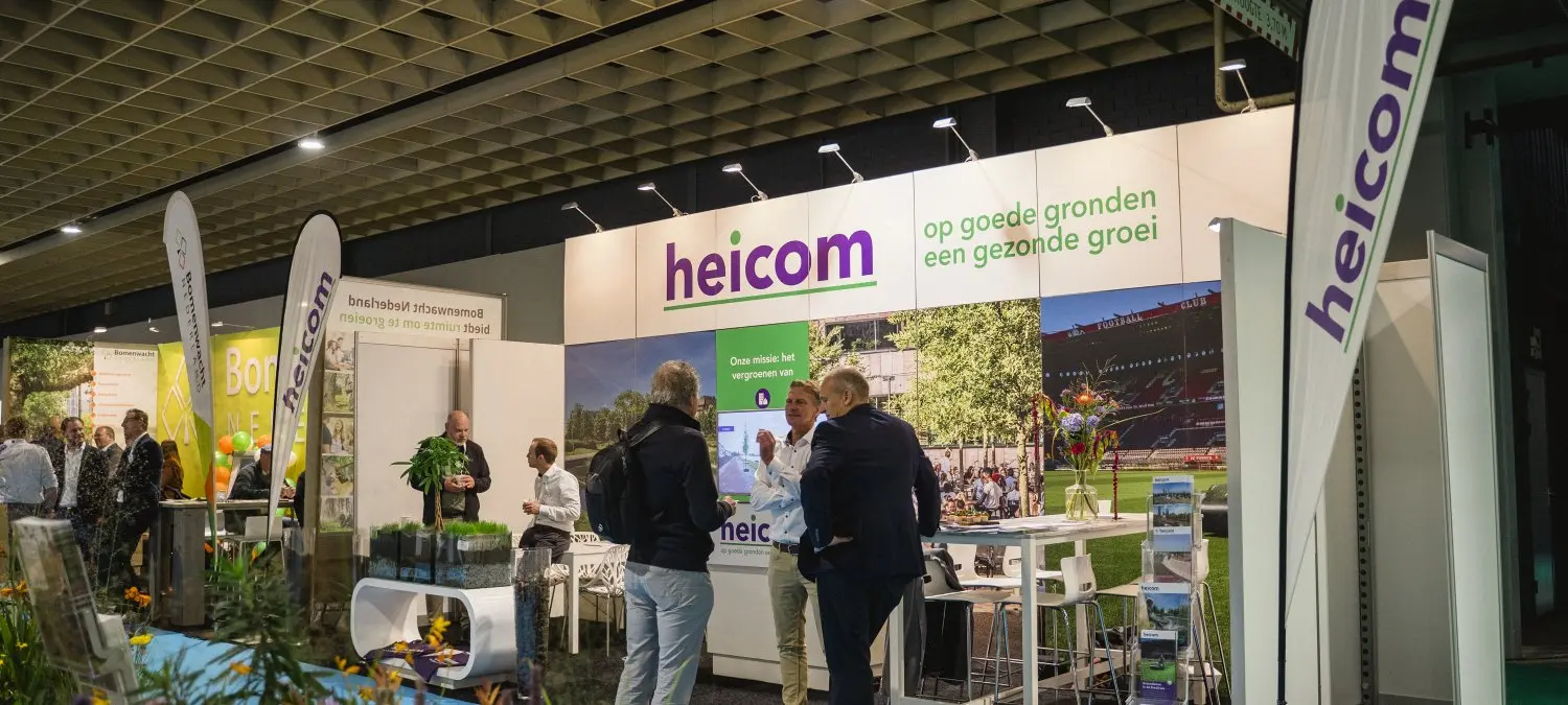 Bezoekers bij de verlichte beurswand van Heicom met plantenbakken