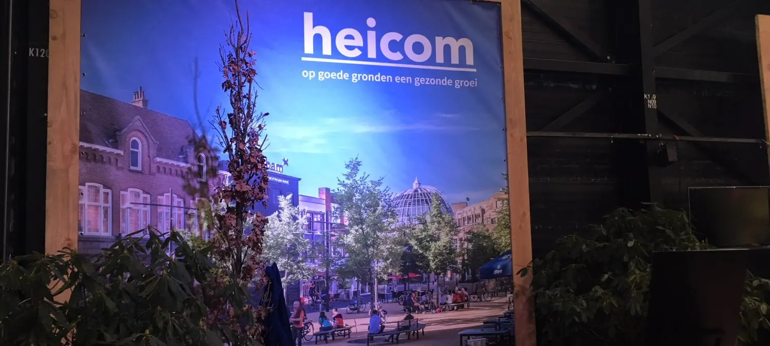 Verlicht Heicom-doek met stadsplein in een houten frame tussen planten