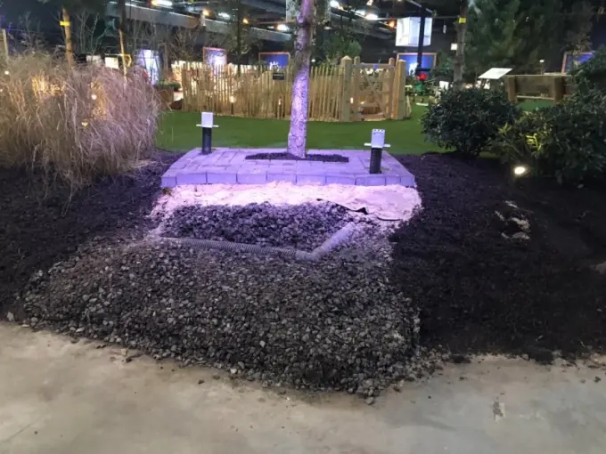 Opengewerkt boomplantvak met lava, zand en mulch op een beursstand