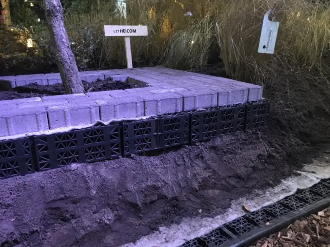 Demo-opstelling met waterbergingskratten onder bestrating bij een bordje Heicom