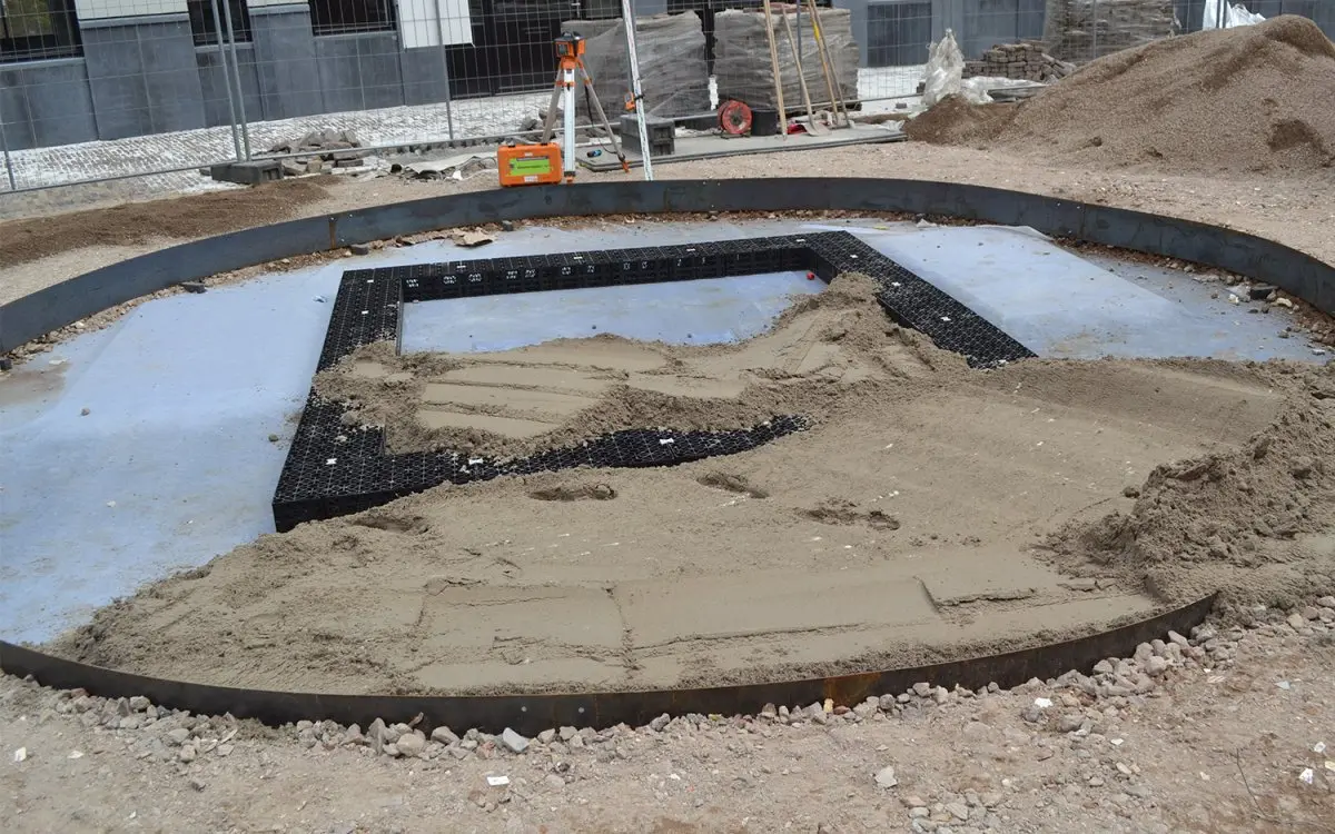 Aanleg van een rond plantvak met kunststof kratten en zand