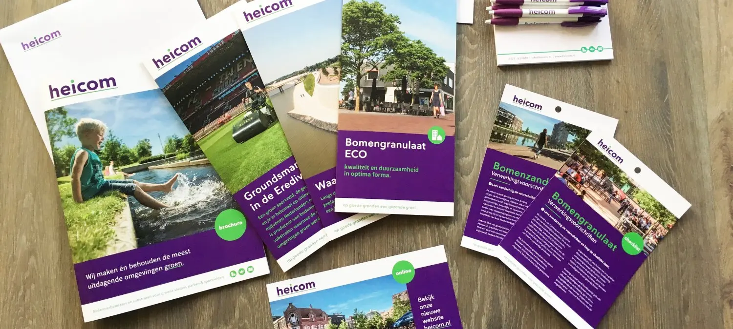 Heicom-brochures, flyers en pennen uitgestald op een houten tafel
