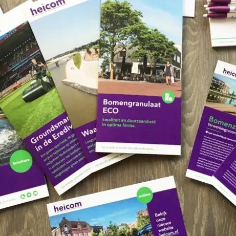 Heicom-brochures, flyers en pennen uitgestald op een houten tafel
