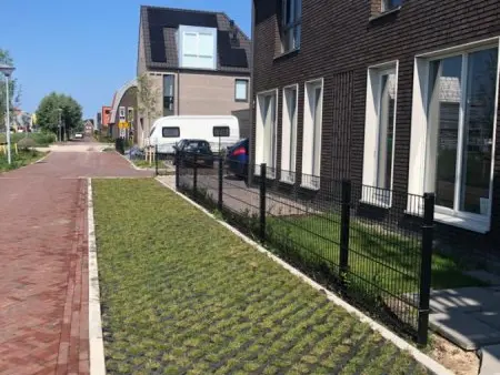 Parkeerstrook met grastegels langs een woning in een nieuwbouwstraat
