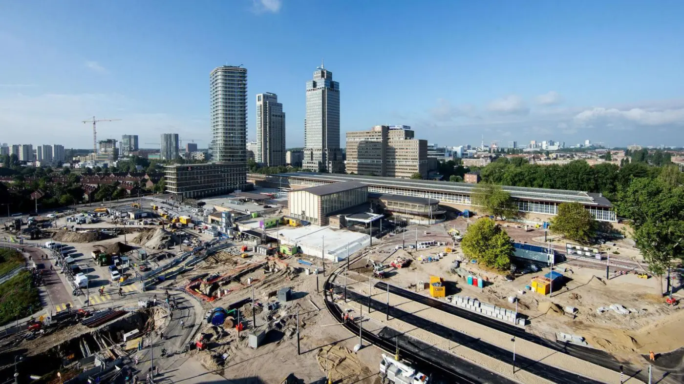 Luchtfoto van een grote bouwput bij een station met hoogbouw