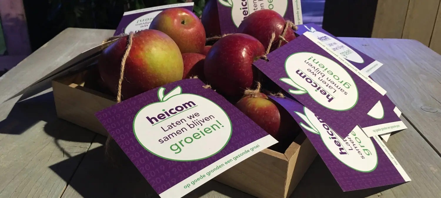 Houten kistje met appels en paarse heicom-kaartjes erbij