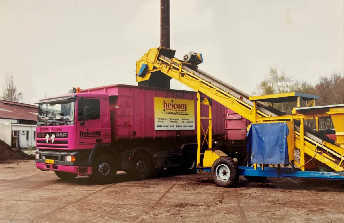 Roze Heicom-vrachtwagen naast een gele zeefinstallatie op het oude bedrijfsterrein