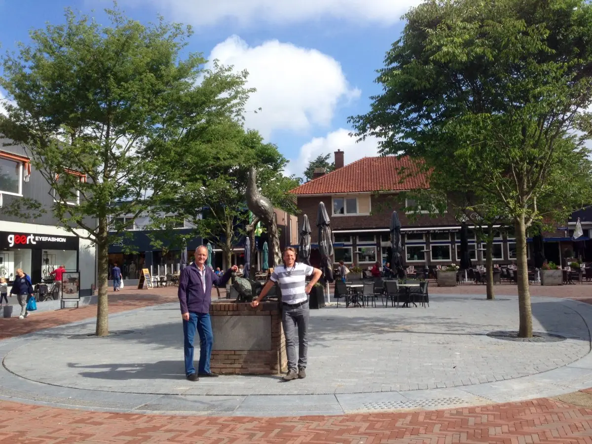 Twee mannen bij een pas heringericht winkelplein met jonge bomen