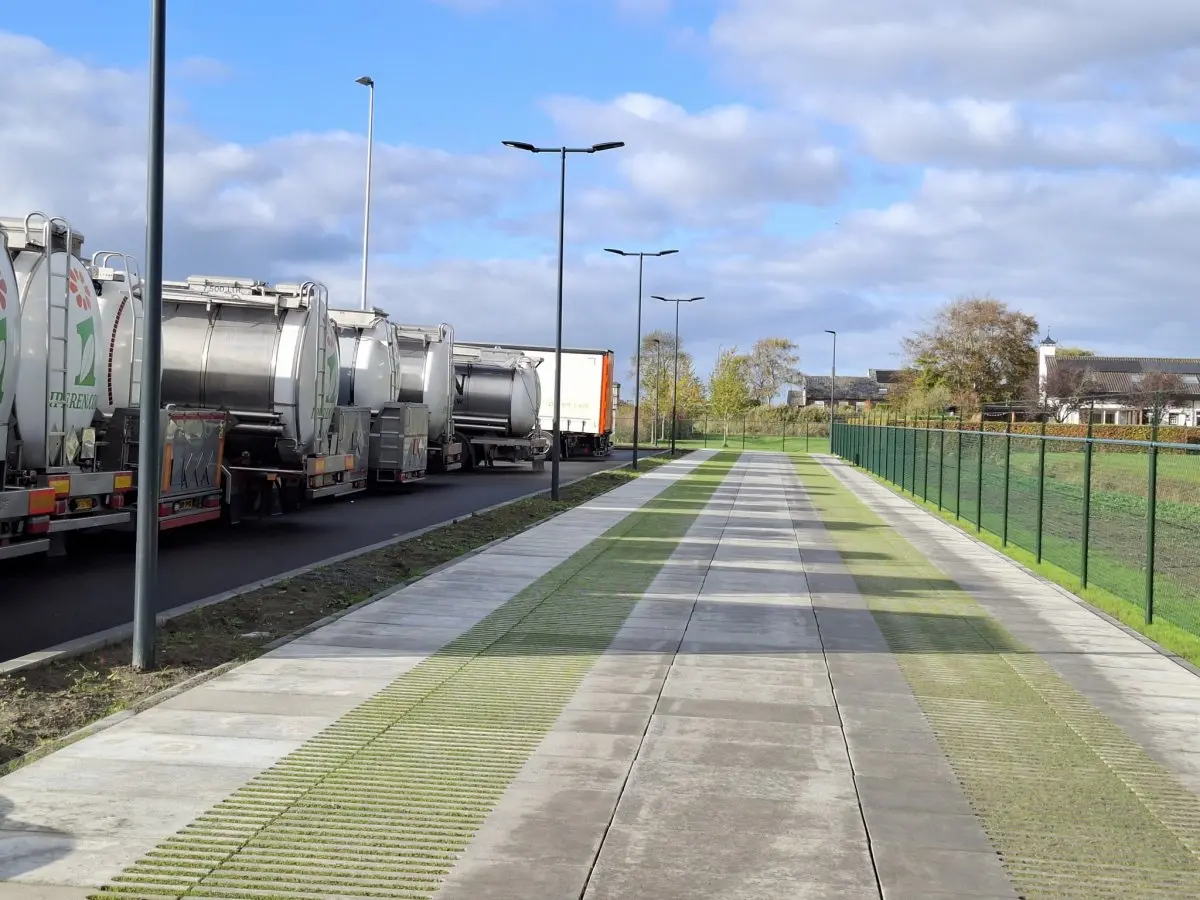 Geparkeerde tankwagens naast parkeerstroken van grasbeton begroeid met gras