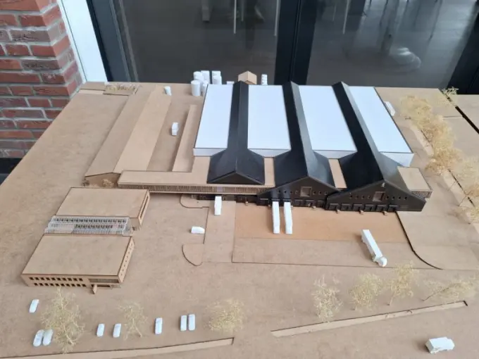 Maquette van een bedrijfsterrein met loodsen en kantoor op een tafel