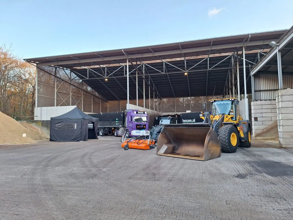 Shovel en vrachtwagen voor een open opslagloods op het bedrijfsterrein