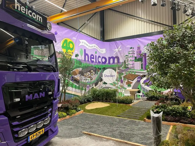 Beursstand van Heicom met paarse vrachtwagen en aangelegde voorbeeldtuin