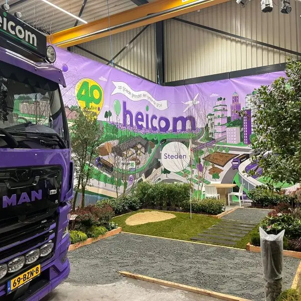 Beursstand van Heicom met paarse vrachtwagen en aangelegde voorbeeldtuin