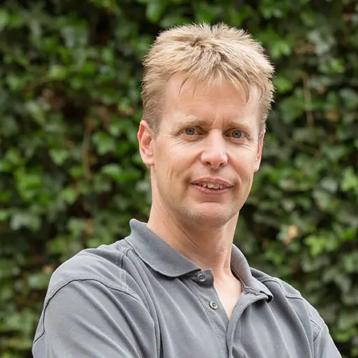 Portret van Gerard Schakelaar in grijs poloshirt voor een klimopmuur