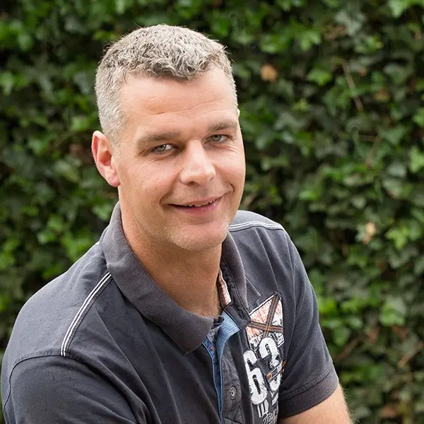 Portret van Herbert van Werven in donkere polo voor een klimopmuur