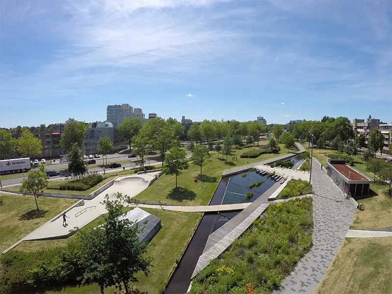 Luchtfoto van een stadspark met skatebaan, waterloop en wandelpaden