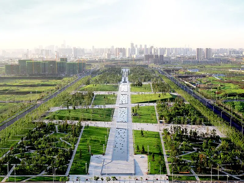 Luchtfoto van een groot stadspark met lange waterpartij en skyline