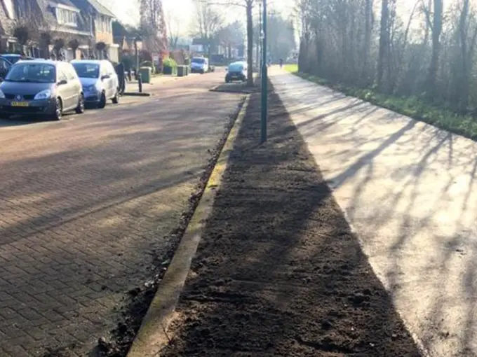 Strook verse grond tussen een woonstraat en een fietspad