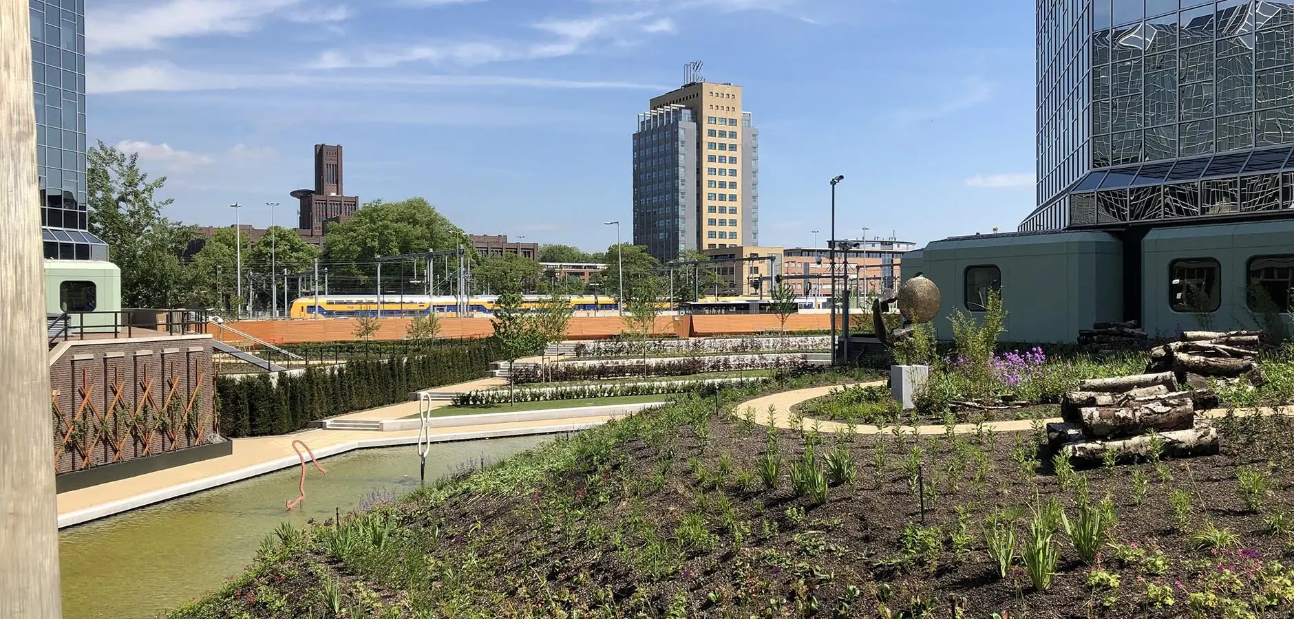 Pas ingeplante daktuin met uitzicht op het spoor en kantoortorens