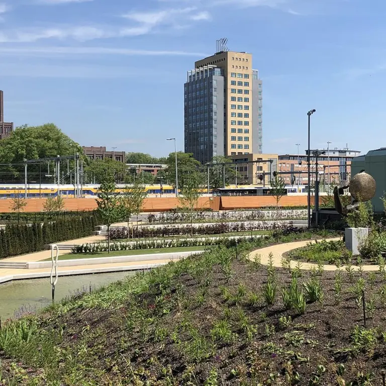 Pas ingeplante daktuin met uitzicht op het spoor en kantoortorens