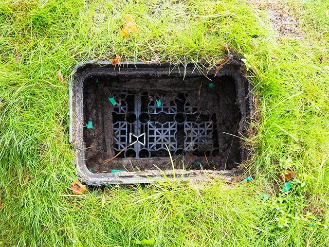 Open put in een grasveld met zwarte kunststof waterbergingskratten eronder