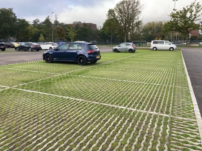 Parkeervakken van grasklinkers met gras en geparkeerde auto's in de herfst