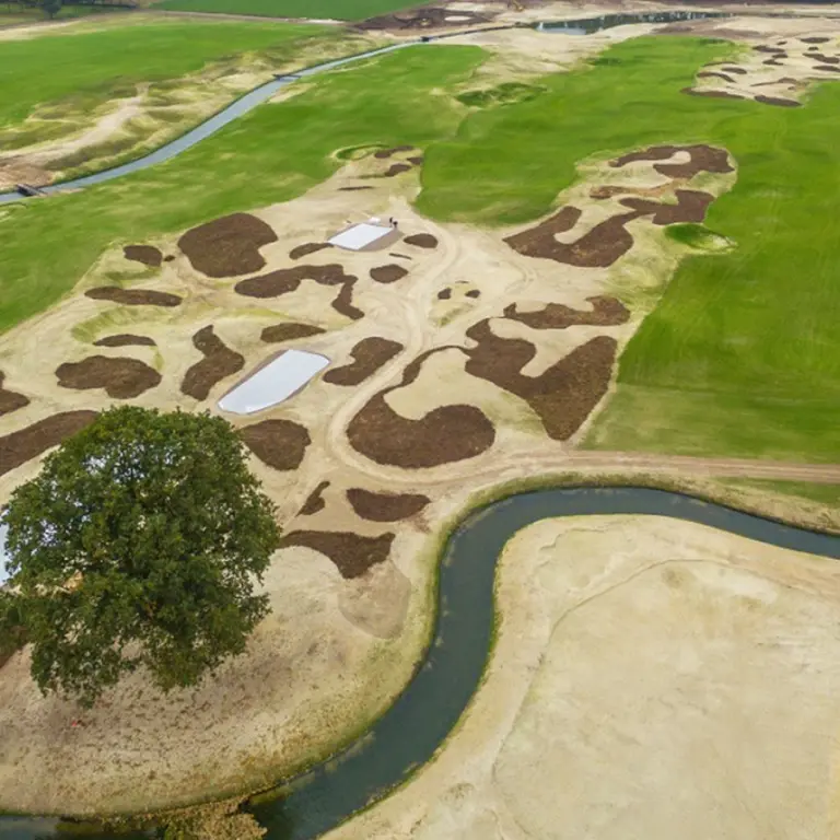 Luchtfoto van een golfbaan in aanleg met bunkers en grondwerk