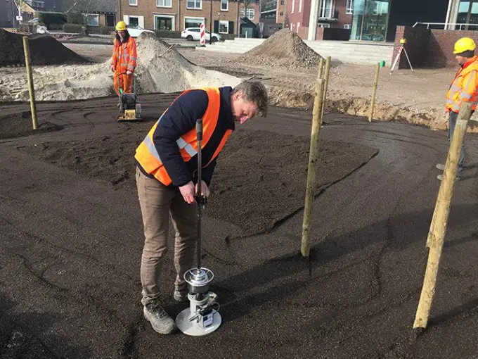 Man voert een meting uit op donkere grond met meetapparaat