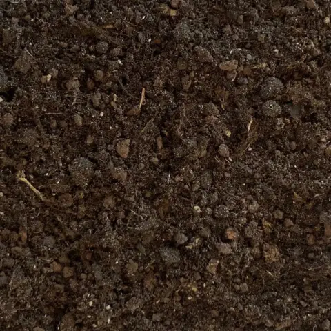 Bruin kruimelig substraat met plantenvezels en kluitjes van dichtbij