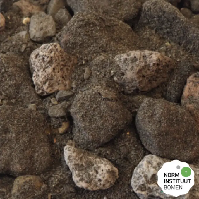 Grove basalt- en lavabrokken vermengd met bruine voedingsgrond