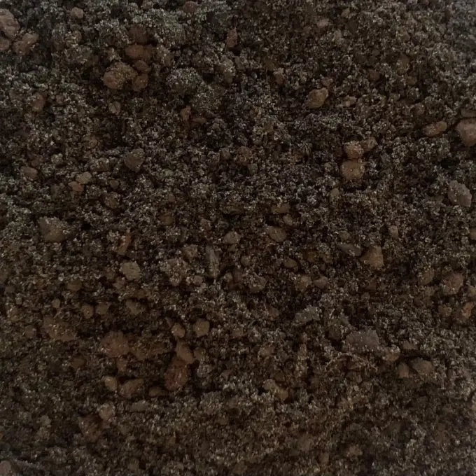 Donkerbruine daktuingrond met roodbruine korrels tussen fijn zand