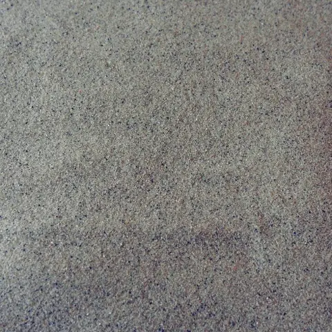 Gladgestreken fijn beigegrijs zand met donkere spikkels