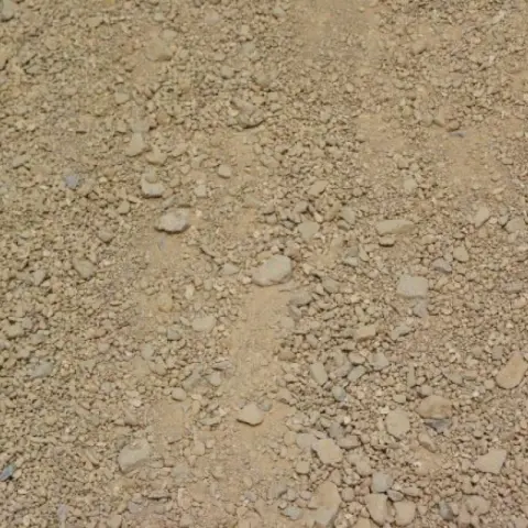 Zandkleurige gravelverharding met verspreide steentjes, van bovenaf
