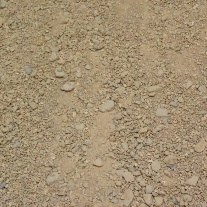 Zandkleurige gravelverharding met verspreide steentjes, van bovenaf