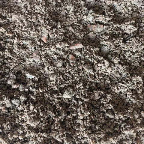 Grijsroze granietsplit vermengd met donkere grond