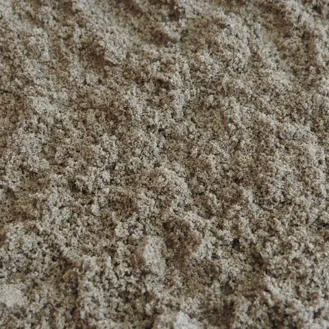 Losse hoop beigebruin zand met grijze en witte korrels