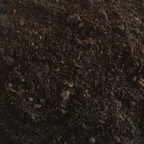 Donkerbruine grond met vezelige plantenresten en kleine kluitjes